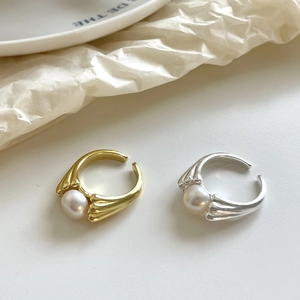 Detail of adjustable 925 silver pearl rings in gold and silver with wave textured bands