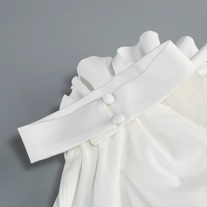 Détails de la robe dos nu blanche avec des volants multicouches et fermeture à boutons