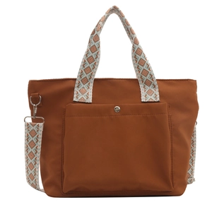 Brown nylon tote bag with wide geometric pattern strap and front snap pocket