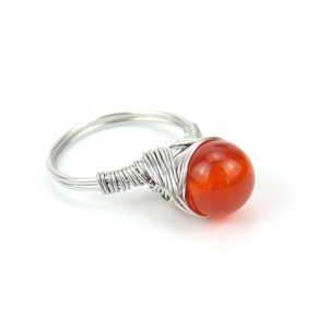Detailed shot of handmade silver wire wrapped ring with a round orange carnelian bead