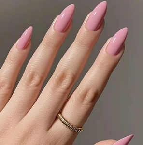 Gros plan d'ongles amande roses brillants avec une bague dorée texturée minimaliste