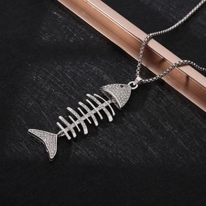 Macro shot of silver fishbone pendant necklace with sparkling zircons on black surface