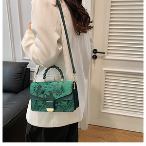 Détail du sac à main vert foncé avec broderie en dentelle et appliqués papillon 3D