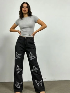 Vue détaillée du motif papillon élégant sur le jean gris foncé pour femme à coupe droite