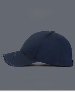 Detail of navy blue distressed baseball cap with frayed brim and twill cotton texture