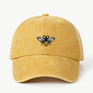 Detailed macro view of the yellow vintage cotton baseball cap with bee embroidery