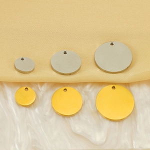 Minimalist round 18k gold and silver pendants in three sizes on textured background