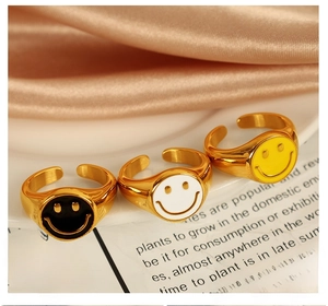 Detailed view of three 18K gold plated smiley rings in black, white and yellow enamel