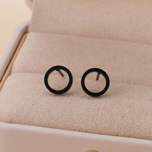 Close-up of black matte stainless steel hoop earrings in a beige velvet jewelry box