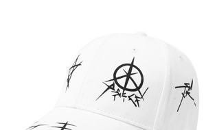 Dettaglio del cappello bianco con stelle graffiti nere e stampe astratte su twill di cotone
