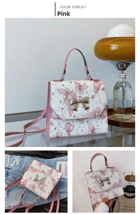 Detail of pink butterfly pattern and gold metal bow clasp on creamy PU leather bag