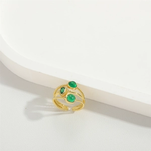 Macro detail of triple-layered gold band ring set with three green zircon stones