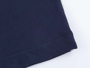 Détail du tricot bleu marine avec dentelle blanche latérale et coutures de haute qualité