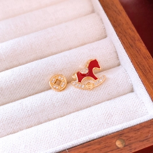 Détail de boucles d'oreilles plaquées or 18 carats avec cheval à bascule et pièce en cuivre