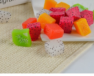 Detailed view of realistic artificial dragon fruit, mango, and kiwi cubes in a dish