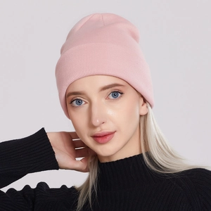 Pink knit beanie for men and women, stylish winter hat shown on model for outdoor wear