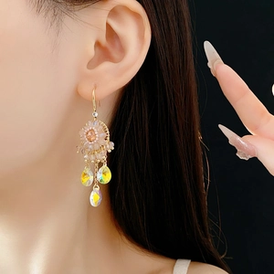 Detail of bohemian gold earrings with champagne crystals and iridescent waterdrop tassels