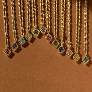 Close-up of gold-plated twisted chains with colorful rhinestone rhombus pendants