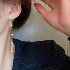Detail of long tassel pearl earrings with double-strand chain and silver finish