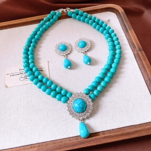 Close-up of vintage turquoise jewelry set with double-layer beaded necklace and drop earrings
