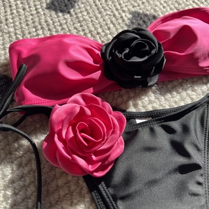 Detail of two-piece bikini featuring 3D satin roses and side-tie contrast drawstrings