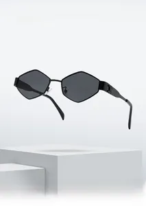 Detail shot of black geometric frame sunglasses featuring gold metal logo on the temple