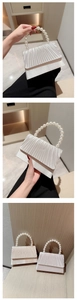Detailed view of elegant satin pleated evening bag with pearl bead handle in gold and silver
