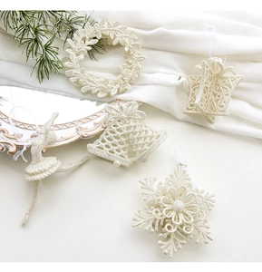 Detailed view of white glitter Christmas ornaments with snowflake and bell shapes