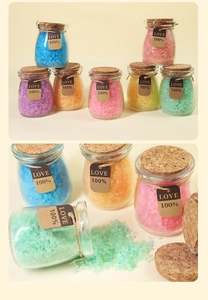 Macro view of colorful mineral bath salts in glass jars with cork lids and heart tags
