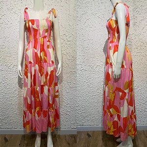Close-up of bohemian spaghetti strap dress with pink floral print and tiered skirt layers