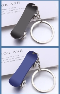 Detail view of mini metal skateboard keychains in matte black and blue finish
