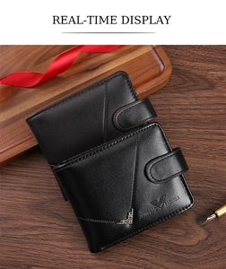 Close-up of black leather wallet with diagonal stitching and decorative metal corners