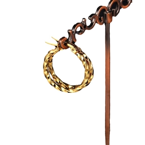 Gold twisted rope style hoop earrings in stainless steel on a vintage display stand
