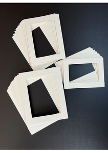 Detail showing thick white mat boards with precise bevel cut edges for picture frames