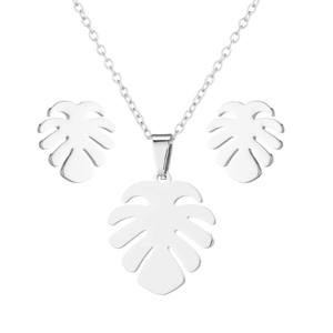 Silver monstera leaf necklace and earrings set in polished metal on white background