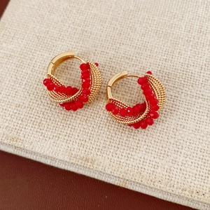 Close-up of vintage hoop earrings with red beads and golden twisted mesh detailing