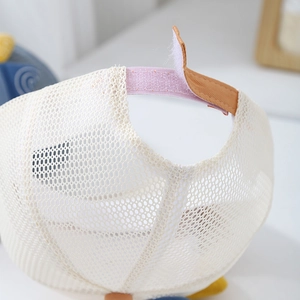Close-up of breathable mesh fabric and adjustable velcro strap on kids dinosaur cap