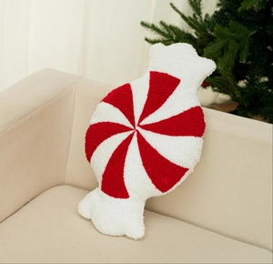 Nahaufnahme von rot-weißem Zuckerstangen-Kissen auf Sofa mit festlichem Weihnachtsbaum