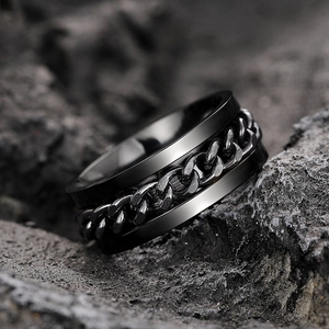 Macro detail of black rotatable Cuban chain ring with a brushed stainless steel texture