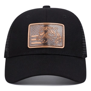 Detail of the rectangular brown leather patch with tiger and flag on black mesh cap
