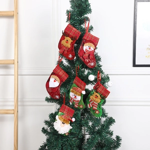Red and green plaid Christmas stockings with 3D Santa and reindeer hanging on a tree