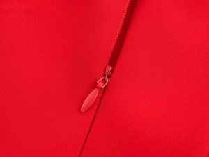 Close-up of red balloon dress fabric featuring a high-quality invisible zipper detail