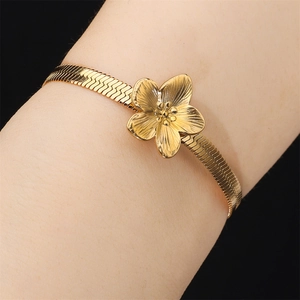 Elegant gold flower bracelet featuring a flat snake chain and textured floral charm