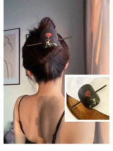Détail d'un pic à cheveux en cuir vintage avec imprimé rose rouge et finition mate