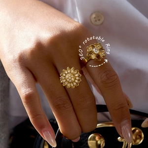Detail of gold rotating sunflower rings with white cubic zirconia on a female hand