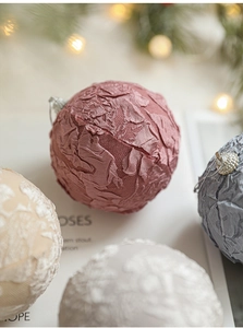 Detailed close-up of pink fabric-covered Christmas foam ball with intricate lace texture