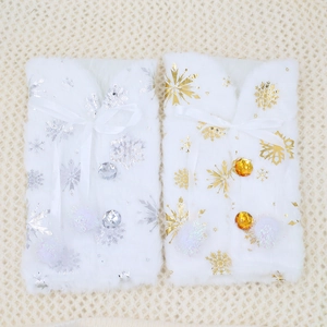 Detail of plush Christmas wine bottle covers with gold and silver snowflake patterns