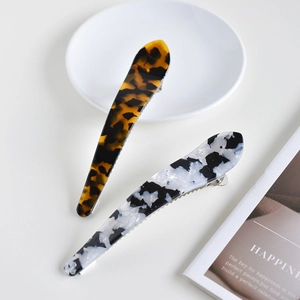 Detail view of large acetate claw clips in amber leopard and black white marble patterns
