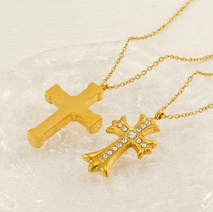 Detail of gold-tone cross necklaces showing polished plain and zircon-encrusted designs