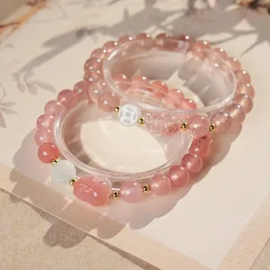 Chic pink strawberry quartz beaded bracelet with gold accents and a carved cat charm